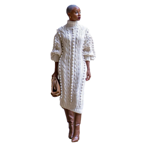 Woman wearing a ivory cable knit sweater dress with brown boots on a white background