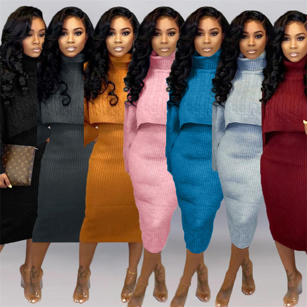 Six women standing side by side wearing matching ribbed knit two-piece sets in different colors: black, charcoal gray, mustard yellow, light pink, bright blue, pale blue, and burgundy. Each set includes a turtleneck top and a fitted midi skirt.