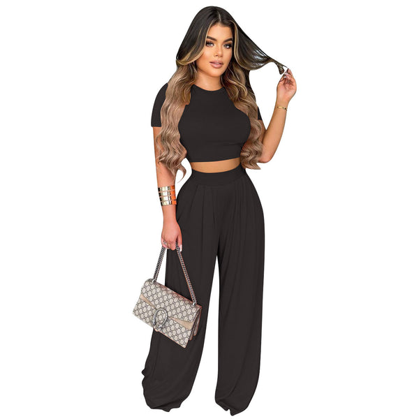 Woman in black outfit holding a handbag on a white background