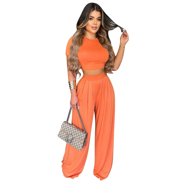 Woman in an orange outfit holding a handbag on a white background