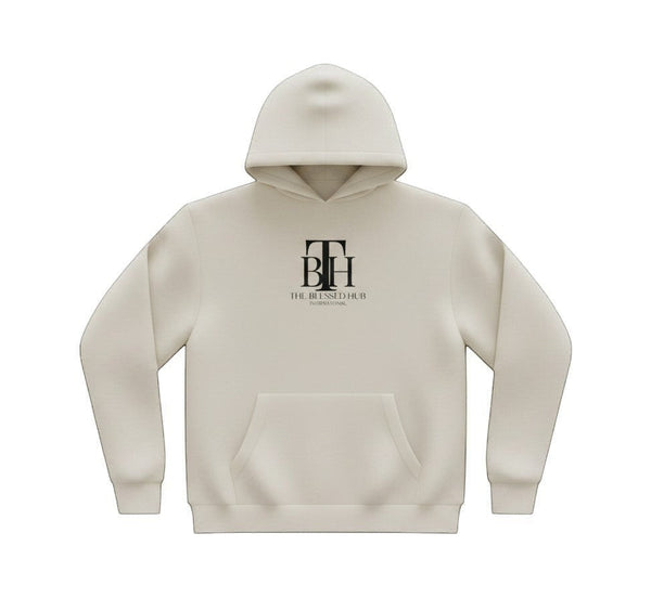 SlayEdgeBoutique beige pullover hoodie with The Blessed Hub International logo, kangaroo pocket, and drawstring hood.