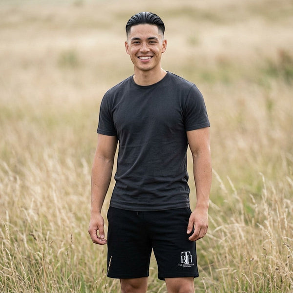 SlayEdgeBoutique athletic lounge shorts in black worn by a smiling man in a field with a grey t-shirt