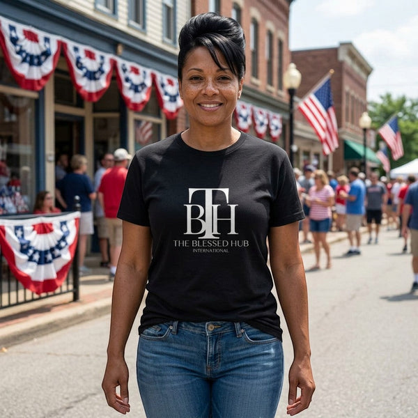 SlayEdgeBoutique black crewneck t-shirt with white TBH logo worn by a woman on a sunny street with American flags.