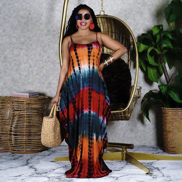 Model wearing a SlayEdgeBoutique sleeveless tie-dye maxi dress with spaghetti straps and a vibrant orange and black print