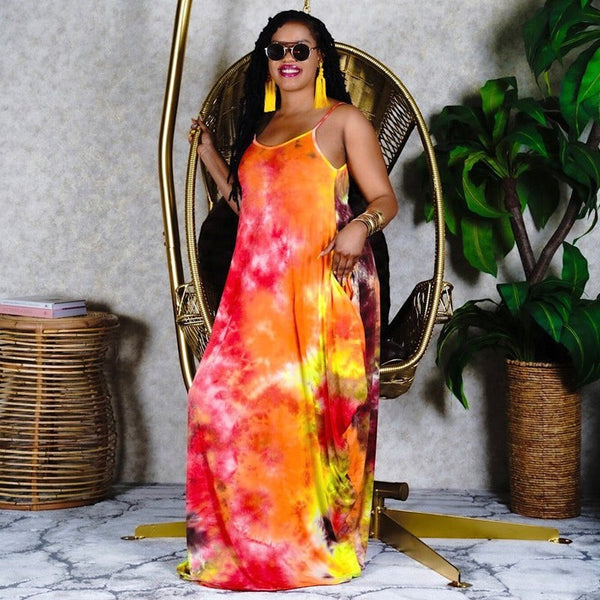 Model wearing a SlayEdgeBoutique sleeveless maxi dress with a vibrant orange, red, and yellow tie-dye print.